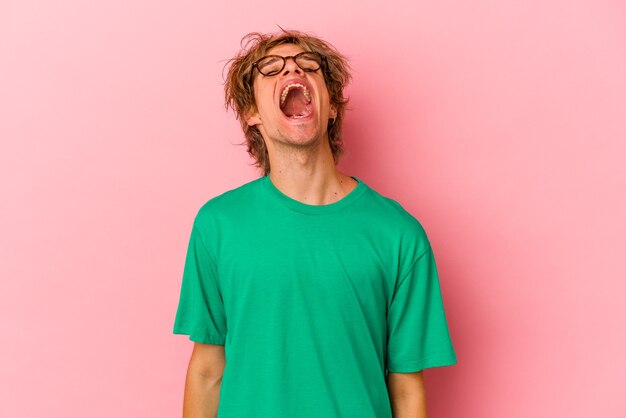 Hombre caucásico joven con maquillaje aislado sobre fondo rosa relajado y feliz riendo, cuello estirado mostrando los dientes.