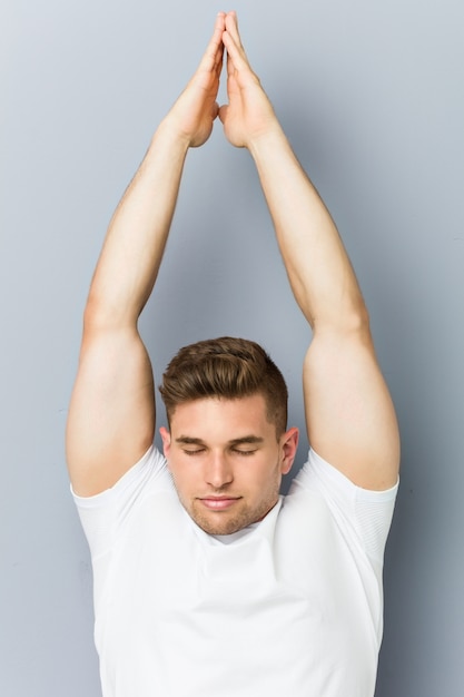 Hombre caucásico joven practicando yoga interior