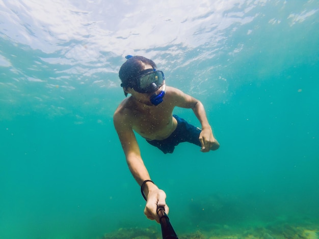 Un hombre caucásico joven que bucea bajo el agua selfie Tailandia.