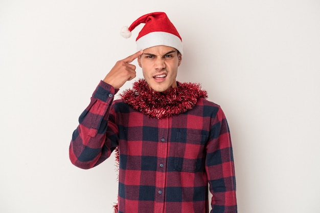 Hombre caucásico joven que celebra la Navidad aislado en el fondo blanco que muestra un gesto de decepción con el dedo índice.