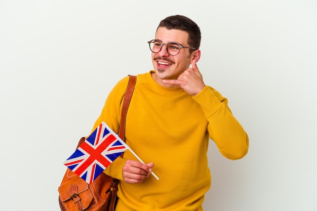 Hombre caucásico joven que estudia inglés aislado en blanco que muestra un gesto de llamada de teléfono móvil con los dedos.