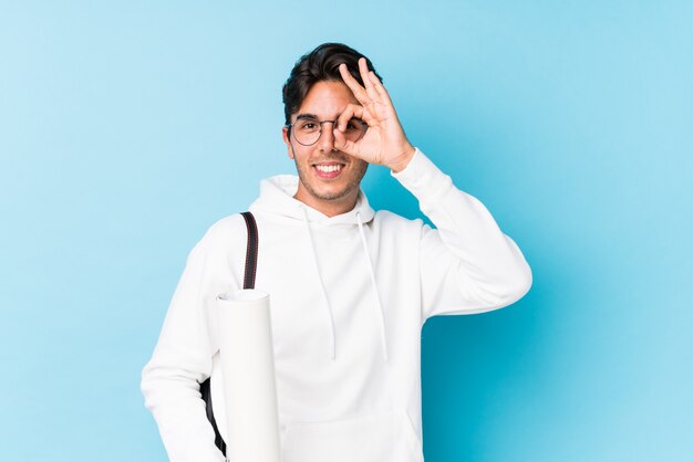 El hombre caucásico joven que estudiaba la arquitectura aislada excitó guardar gesto aceptable en ojo.