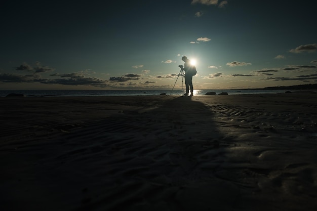 Hombre caucásico joven que hace la foto del paisaje en la playa