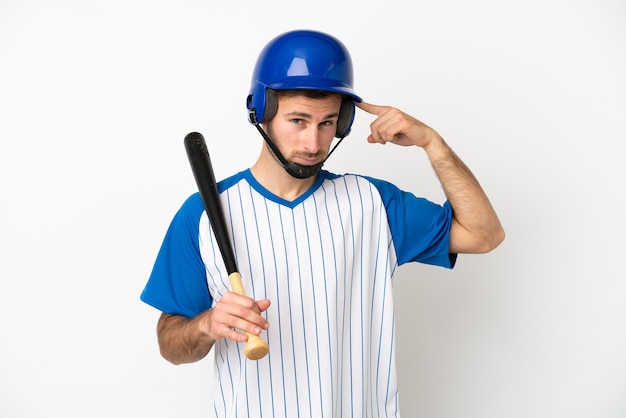 Hombre caucásico joven que juega al béisbol aislado en el fondo blanco que tiene dudas y pensamiento