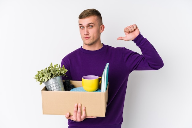 El hombre caucásico joven que se muda a un nuevo hogar se siente orgulloso y seguro de sí mismo