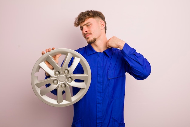 Hombre caucásico joven que se siente estresado ansioso cansado y frustrado concepto de reparador de automóviles