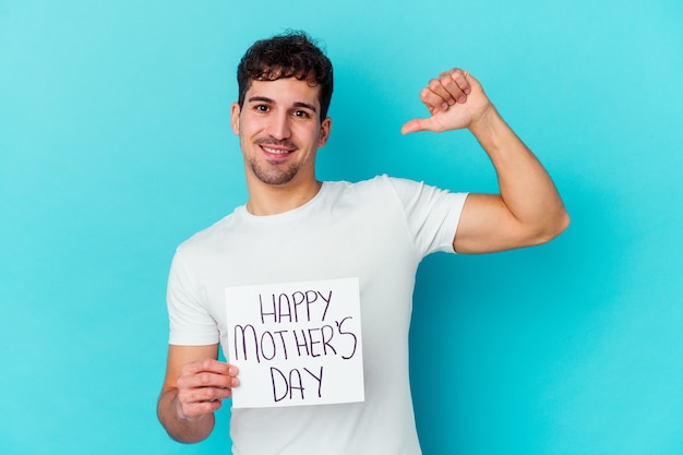 Hombre caucásico joven que sostiene un cartel del día de madres feliz