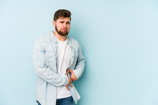 Hombre caucásico joven que tiene un dolor de hígado, dolor de estómago.