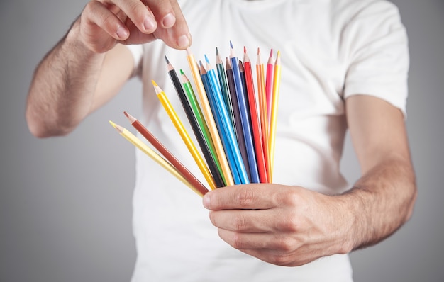 Hombre caucásico con lápices de colores.