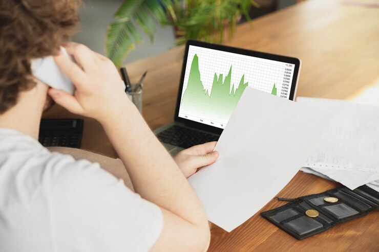 Foto hombre caucásico malestar y desesperación viendo gráficos económicos y financieros bajando