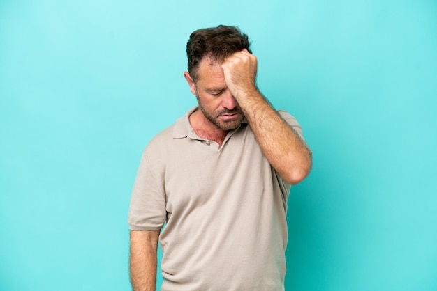Hombre caucásico de mediana edad aislado de fondo azul con dolor de cabeza