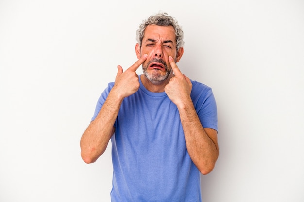 Hombre caucásico de mediana edad aislado sobre fondo blanco llorando, descontento con algo, concepto de agonía y confusión.