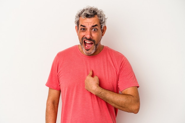 Hombre caucásico de mediana edad aislado sobre fondo blanco sorprendido señalando con el dedo, sonriendo ampliamente.