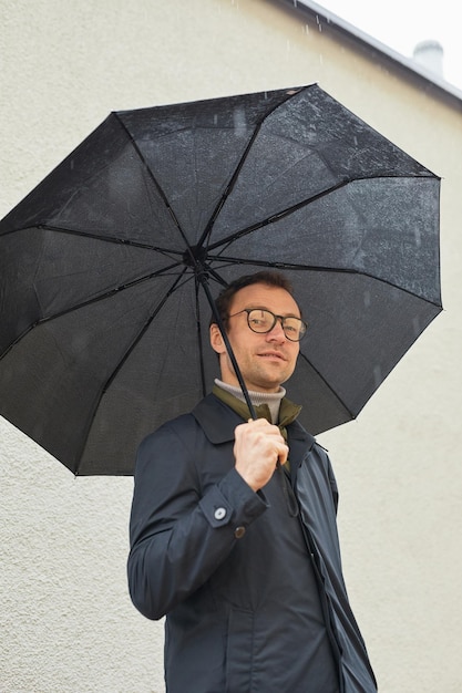 Hombre caucásico moderno con paraguas