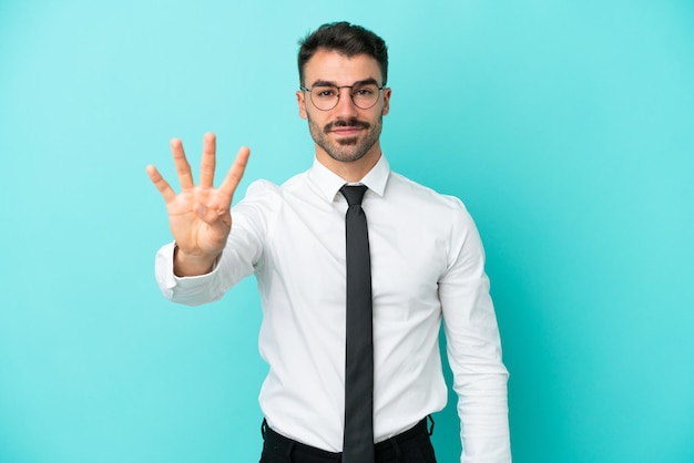 Hombre caucásico de negocios aislado sobre fondo azul feliz y contando cuatro con los dedos