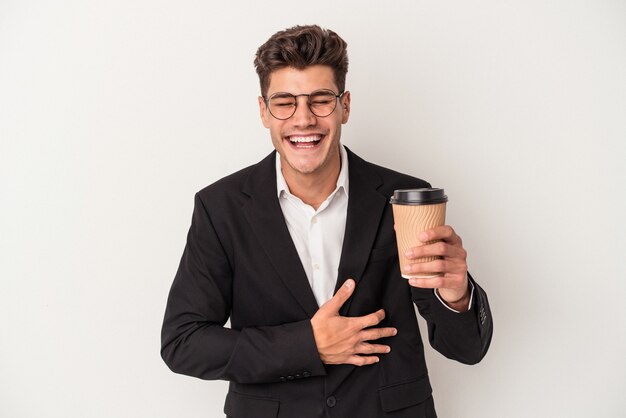 Hombre caucásico de negocios joven sosteniendo café para llevar aislado sobre fondo blanco riendo y divirtiéndose.
