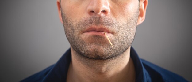 Hombre caucásico con un palillo de madera