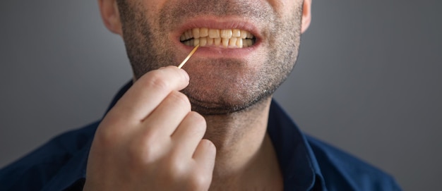 Hombre caucásico con un palillo de madera