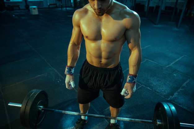 Hombre caucásico practicando levantamiento de pesas en el gimnasio