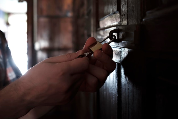 Hombre caucásico que abre la puerta de madera vieja