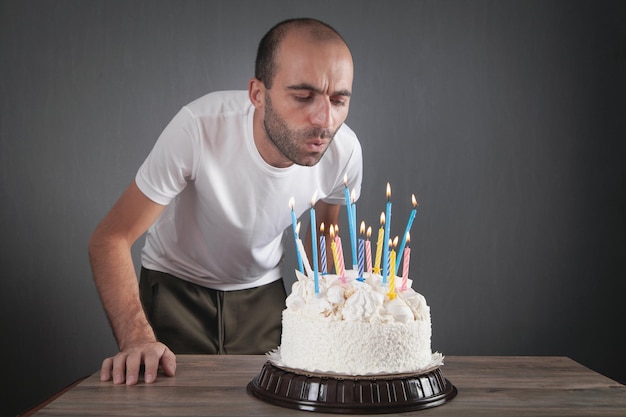 Hombre caucásico que sopla velas de cumpleaños.