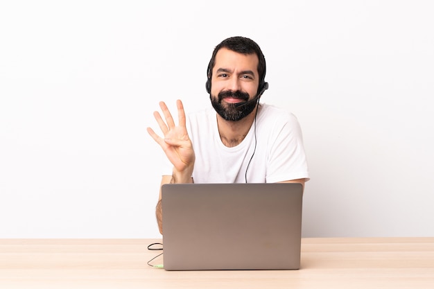 Hombre caucásico de telemarketing que trabaja con un auricular y con un portátil