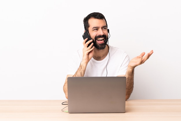 Foto hombre caucásico de telemarketing que trabaja con un auricular y con un portátil