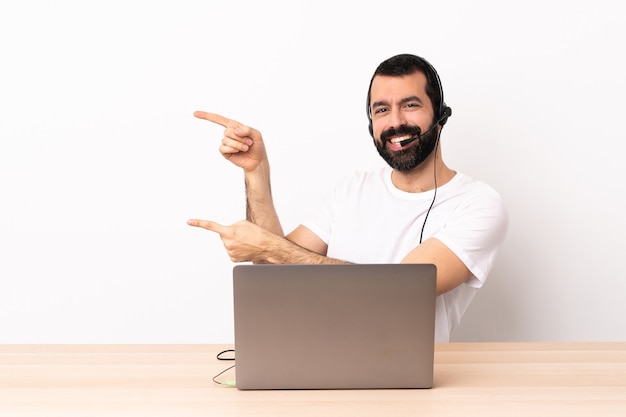 Hombre caucásico de telemercadeo que trabaja con un auricular y con el dedo acusador portátil hacia el lado y presentando un producto.