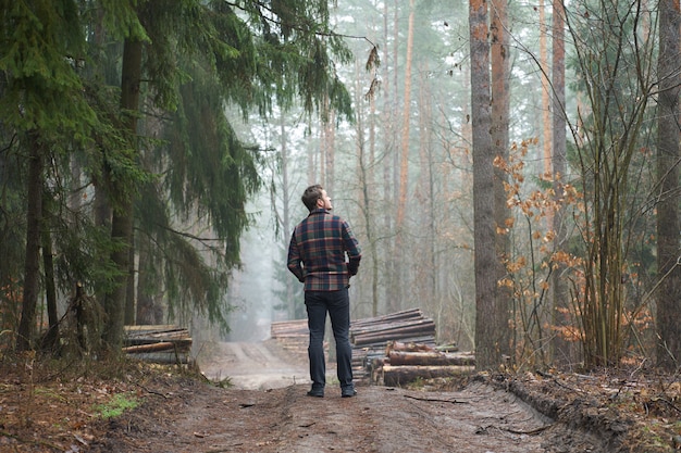 Hombre caucásico tiene un paseo en bosque de niebla