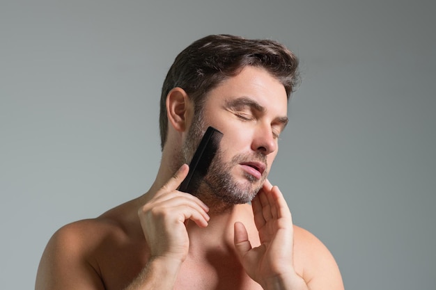 Hombre caucásico tratando de hacer un peine de pelo de barba por sí mismo con peine corte de pelo masculino corte de pelo masculino carber