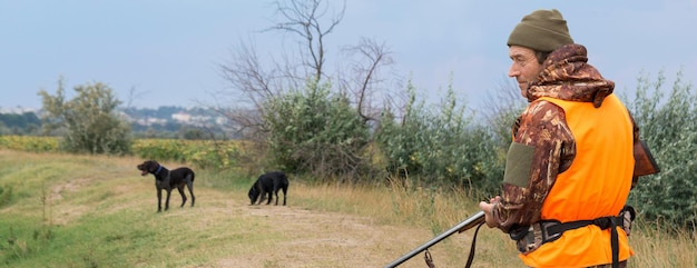 Hombre cazador camuflado con un arma durante la caza en busca de aves silvestres o caza. Temporada de caza de otoño.