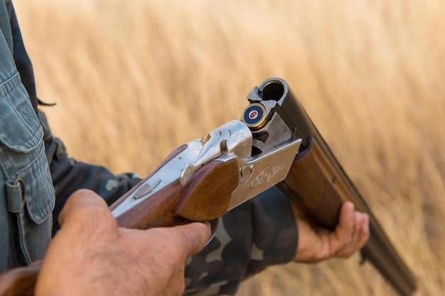 Hombre cazador camuflado con un arma durante la caza en busca de aves silvestres o caza