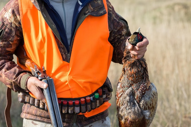 Hombre cazador camuflado con un arma durante la caza en busca de aves silvestres o juego Temporada de caza de otoño