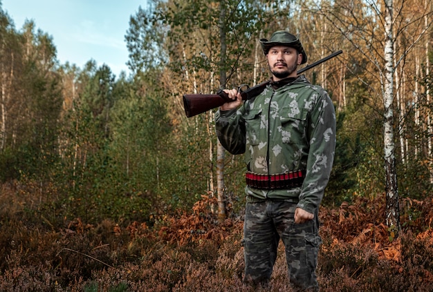 Foto hombre cazador camuflado con una pistola durante la cacería