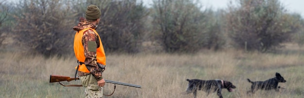 Hombre cazador en camuflaje con una pistola durante la caza en busca de aves silvestres o caza