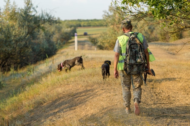 Hombre cazador en camuflaje con una pistola durante la caza en busca de aves silvestres o caza