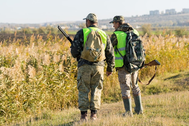 Hombre cazador en camuflaje con una pistola durante la caza en busca de aves silvestres o caza