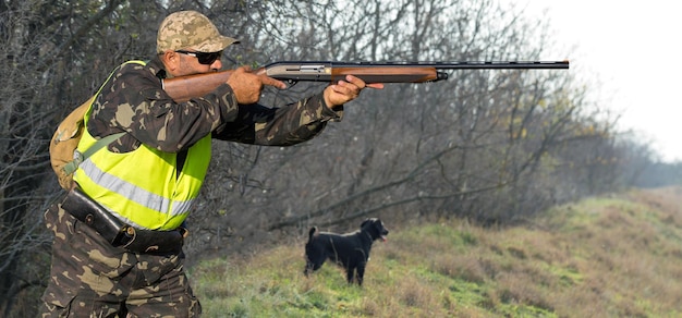 Hombre cazador en camuflaje con una pistola durante la caza en busca de aves silvestres o caza