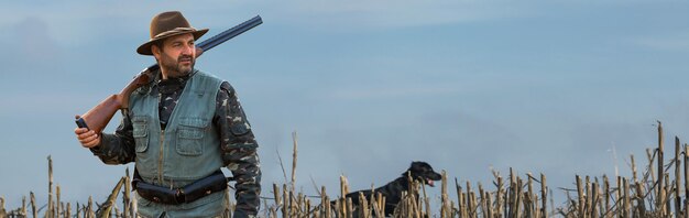 Hombre cazador en camuflaje con una pistola durante la caza en busca de aves silvestres o caza