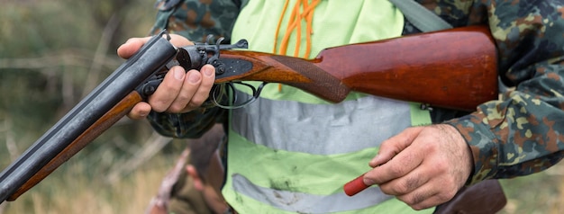 Hombre cazador en camuflaje con una pistola durante la caza en busca de aves silvestres o caza