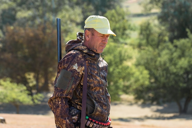 Hombre cazador en camuflaje con una pistola durante la caza en busca de aves silvestres