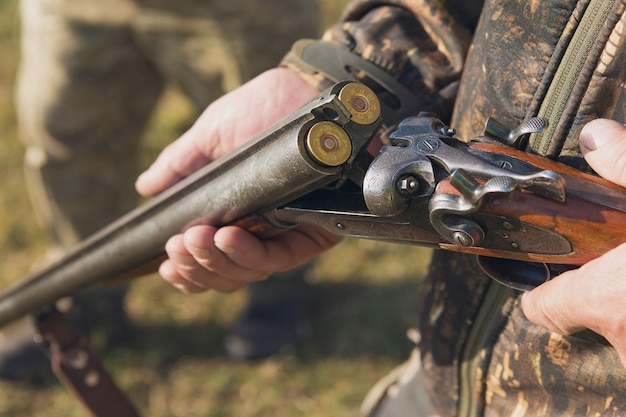 Hombre cazador en camuflaje con una pistola durante la caza en busca de aves silvestres