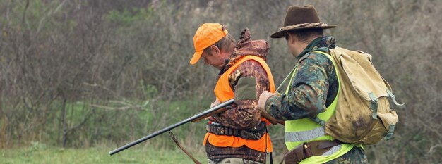 Hombre cazadores en ámbito rural con escopeta y mochila durante la temporada de caza