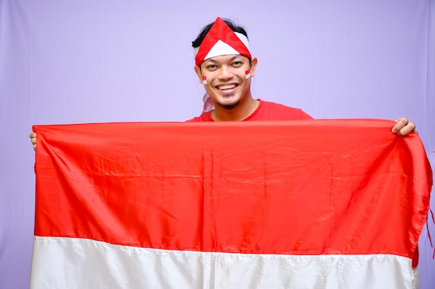 Foto el hombre celebra el día de la independencia de indonesia el 17 de agosto con una bandera de indonesia