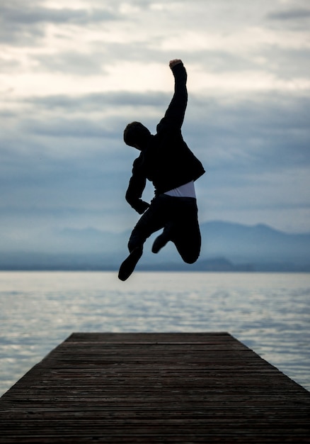 Foto hombre celebrando en el muelle