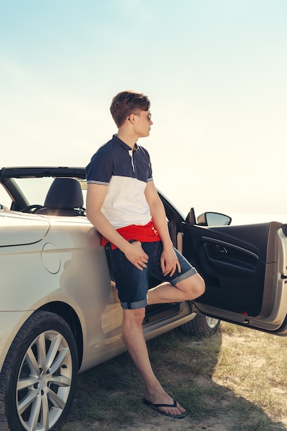 Hombre cerca de coche descapotable al aire libre