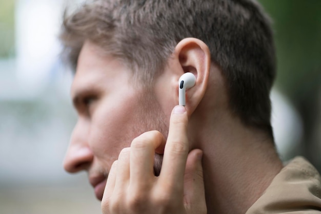 Un hombre de cerca que usa auriculares inalámbricos y escucha la música