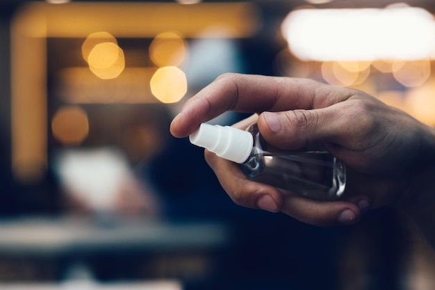 Hombre de cerca rociando spray antiséptico para manos