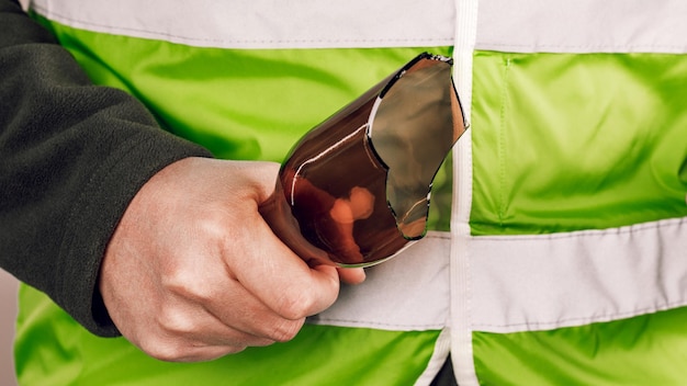 Hombre con chaleco amarillo protestando con una botella rota en las manos