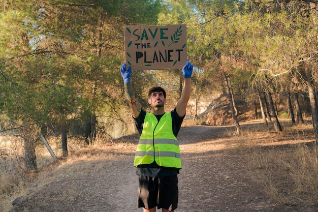 Hombre en un chaleco reflectante con un cartel que protesta por la contaminación global